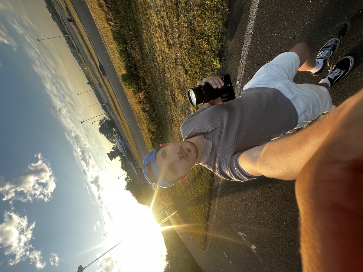 Golden-hour selfie at the kart track, camera in hand