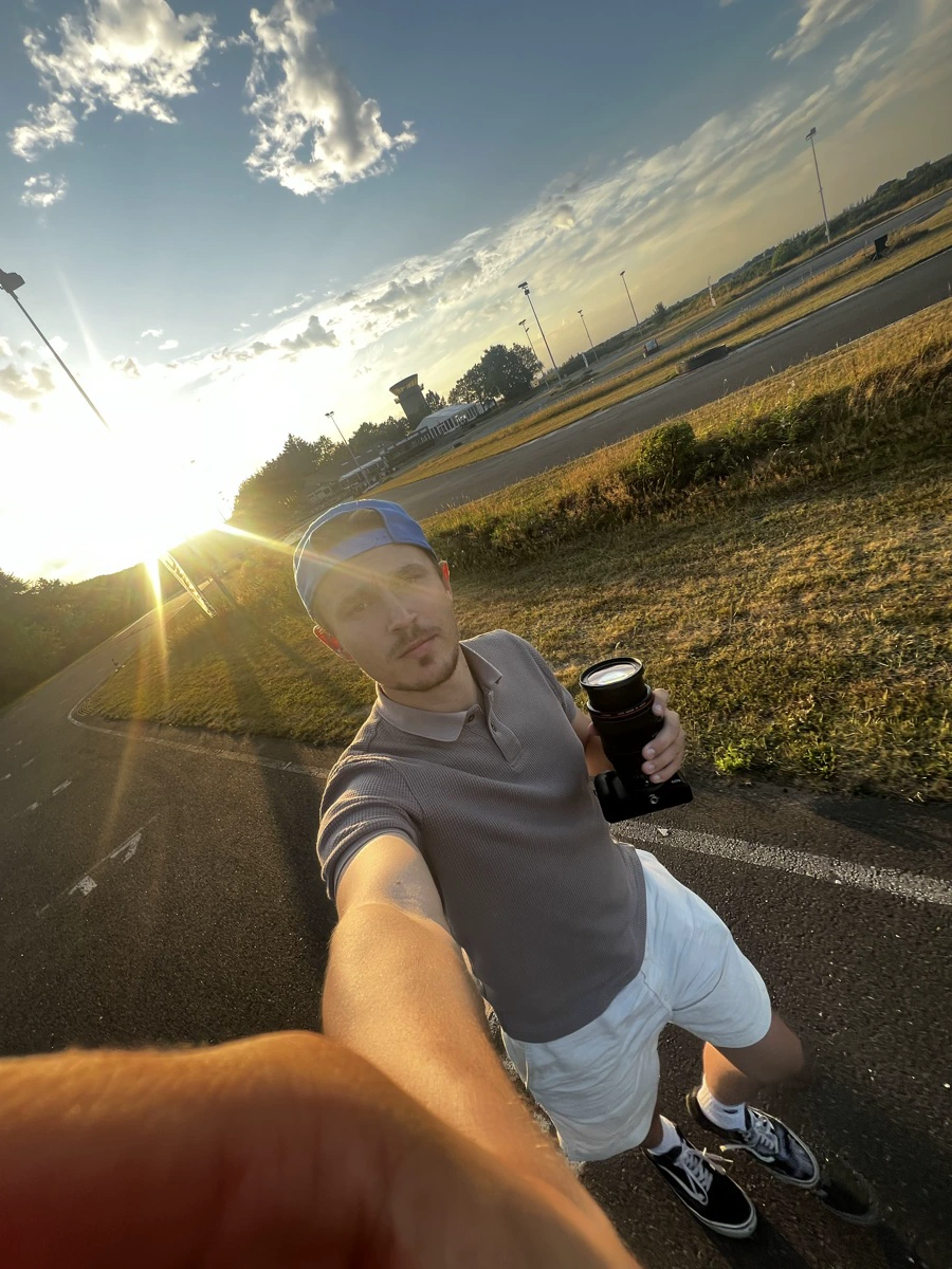 Golden-hour selfie at the kart track, camera in hand