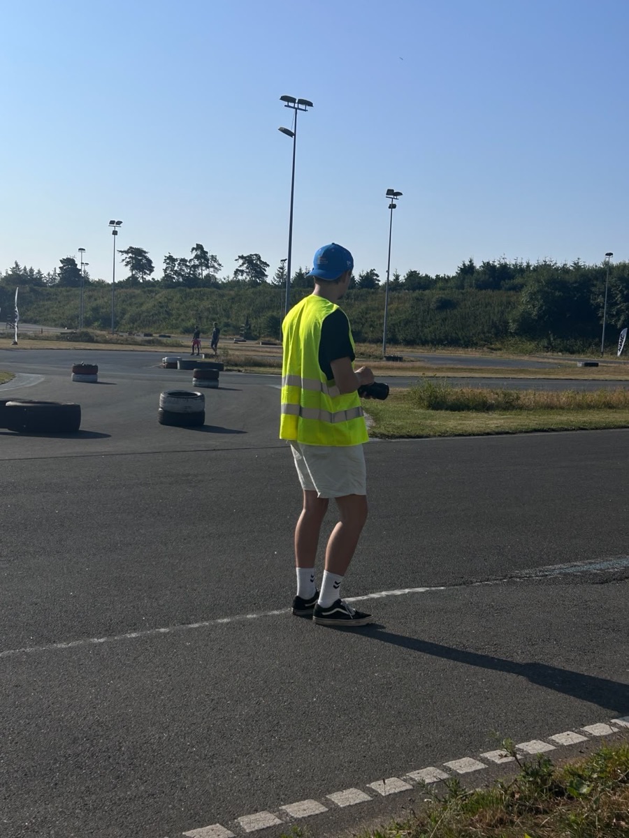 Alexander trackside in a marshal vest, camera in hand, shooting the karting world championship
