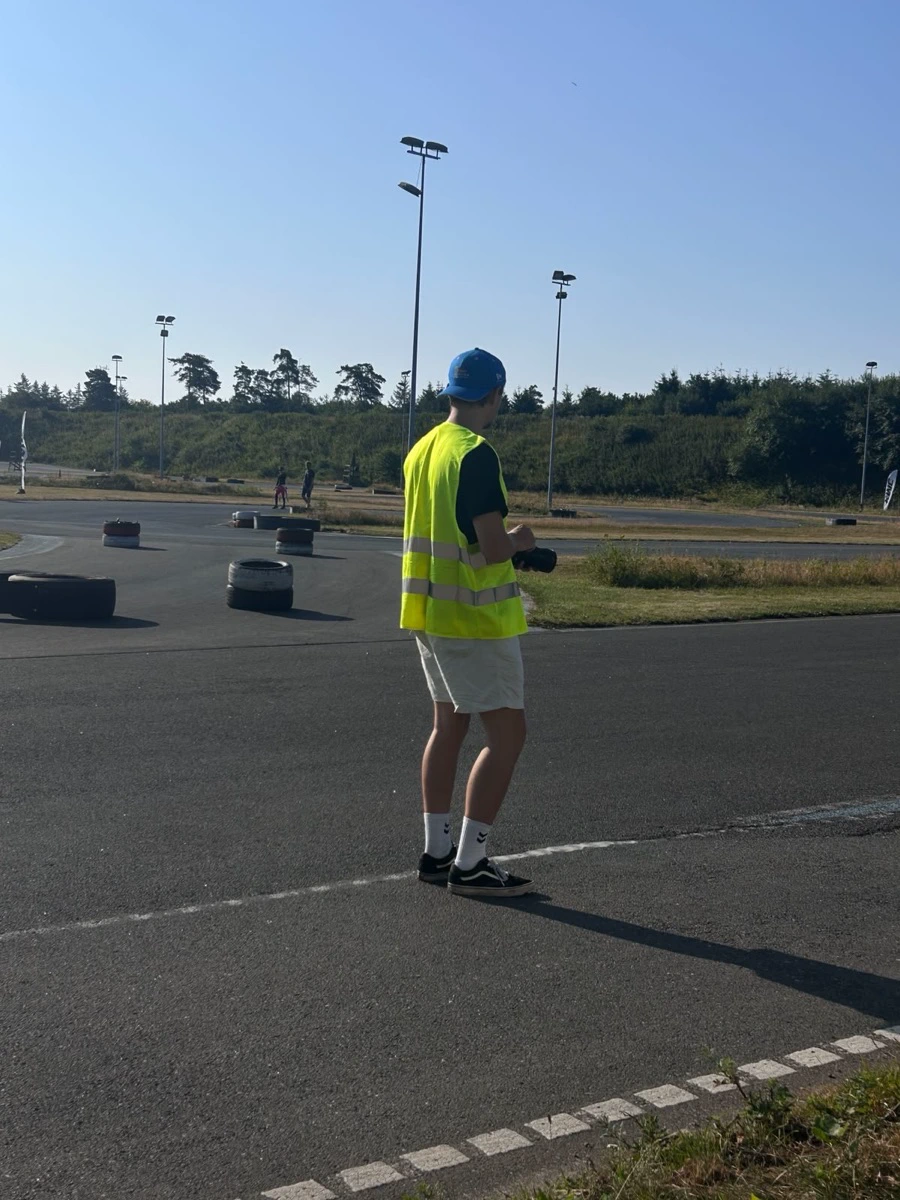 Alexander trackside in a marshal vest, camera in hand, shooting the karting world championship